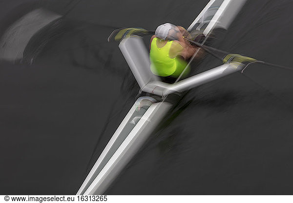 A single scull boat and rower on the water  view from above. Motion blur