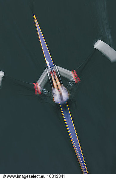 A single scull boat and rower on the water  view from above. Motion blur