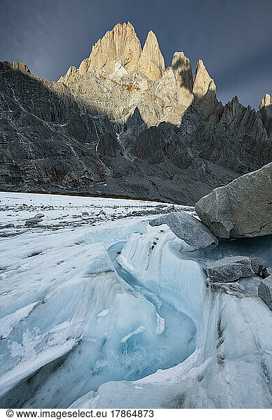 A small river winds its way down the Torre Glacier  with Fitzroy
