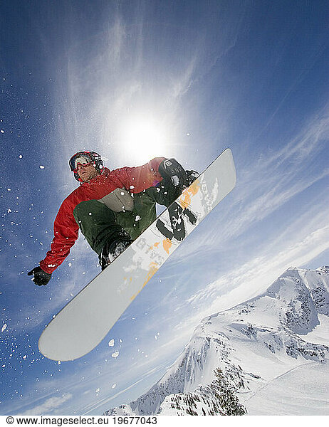 A snowboarder jumping of a cliff at Snowbird  Utah.