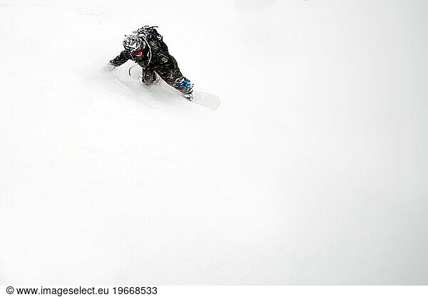 A snowboarder riding on a fresh powder day.