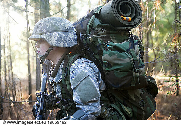 A soldier patrols through the woods during a field training exercise.