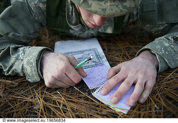 A soldier uses a map during a field training exercise.