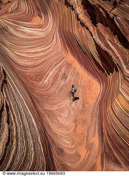 A solitary male hiker inside the famous Wave in North Coyote Buttes