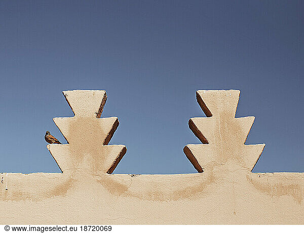 A song bird sits on ornamentation of a building in Marrakesh  Morocco