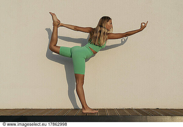 A sporty girl doing yoga and keeps her balance.