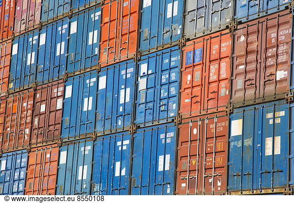 A stack of cargo containers  commercial freight containers  packed together and waiting to be moved.