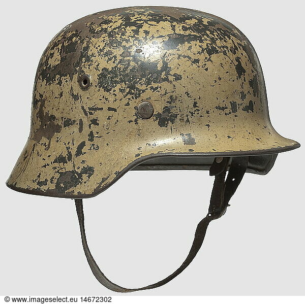 A steel helmet model 1936/40 with single emblem  The shell previously laquered field-grey with impressed air vents  the sand-coloured tropical camouflage 30 % and the re-exposed eagle shield 50 % preserved. Slightly rusted and dented  complete with M 31 interior fittings and chin straps. Signs of wear and age  historic  historical  1930s  20th century  Africa  African  corps  branch of service  branches of service  armed service  object  objects  clipping  cut out  cut-out  cut-outs  military  militaria  defensive arms  weapon  weapons  protective  protection  metal  armour suit  armor suit  suit of armour  piece  pieces  utensil  piece of equipment  utensils  helmet  helmets  headpiece  headpieces  headgear  headgears