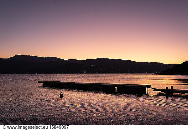 a sunset above a dock with mountains