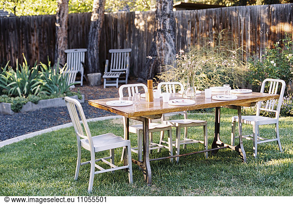 A table in a garden laid for a meal.