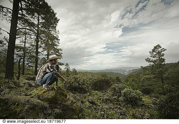 A Tarahumara man sitting on a rock looks to a canyon in Guachochi  Chihuahua  Mexico.