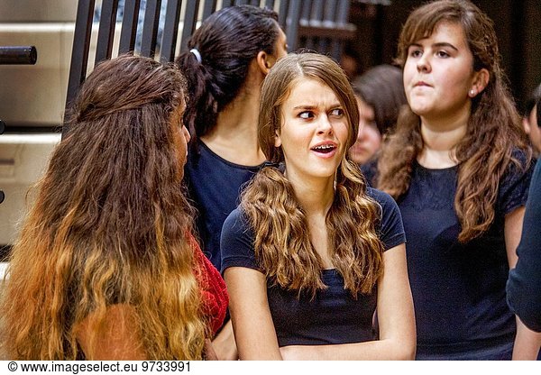 A teen girl reacts with skepticism to a remark by a friend at a concert in an Aliso Viejo  CA  school gymnasium.