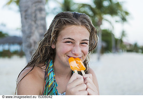 A teenage girl eating a popsicle on holiday