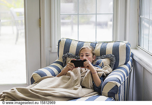 A thirteen year old teenage girl looking at smart phone