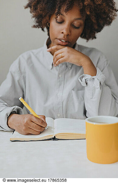 A thoughtful woman writes thoughts in a diary. Selective focus.