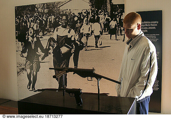 A tourist examines the gun used to kill Hector Pieterson at the Hector Pieterson Memorial Museum in SOWETO Township  Johannesburg  South Africa.
