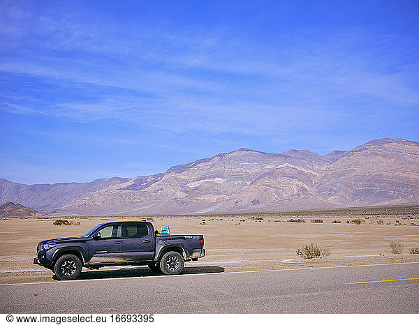 A toyota truck parked on the side of a desert highway  Death Valley