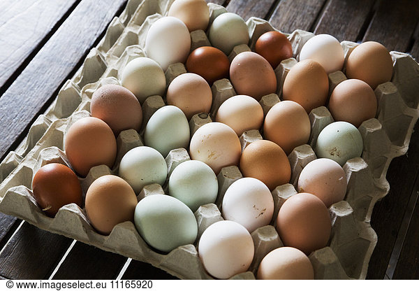 A tray of fresh organic eggs  in a variety of colours.