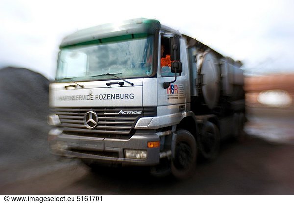 A truck from a Port Service Company provides moistening the roads on the coal- and ore-terminal. This measure provides for a reduction of dust on the terminal. Image made with a ´Lensbaby´.