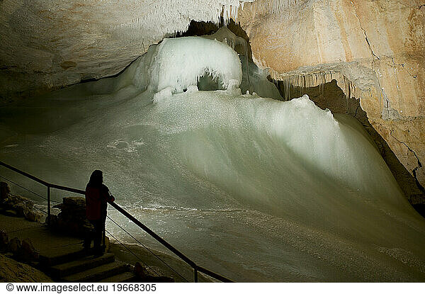 A visitors pauses to admire the icefalls in the Dachstein Ice Caves near Obertraun  Austria.