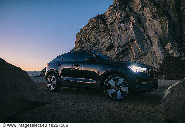 A Volvo C40 - an electric car - parks next to the beach.