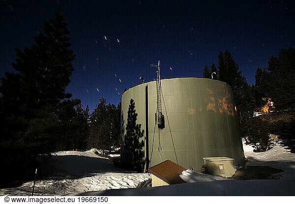 A water tank sits sternly in snow with stars behind  Incline Village  Nevada.