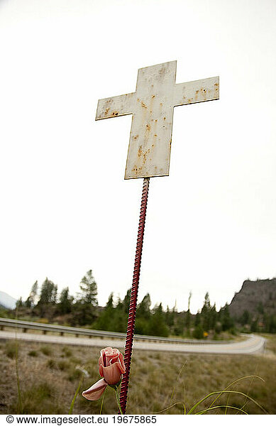 A white cross signifying a death along a dangerous highway.
