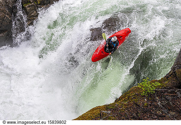 A white water kayaker paddles over a waterfall on the Cheakamus River