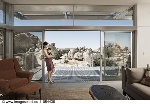 A woman and a young child in the living space of an eco house in the desert.