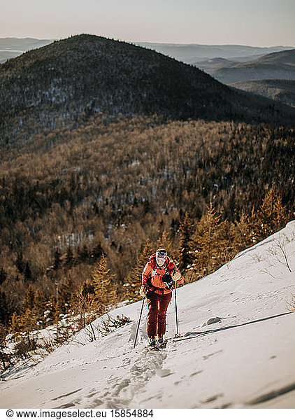 A woman backcountry skis up Baldface Mountain  New Hampshire.