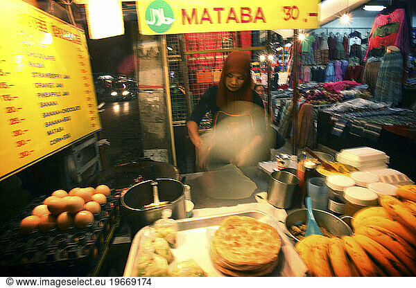 A woman cooking at the night bazaar. Chiang Mai  Thailand. (Motion Blur)