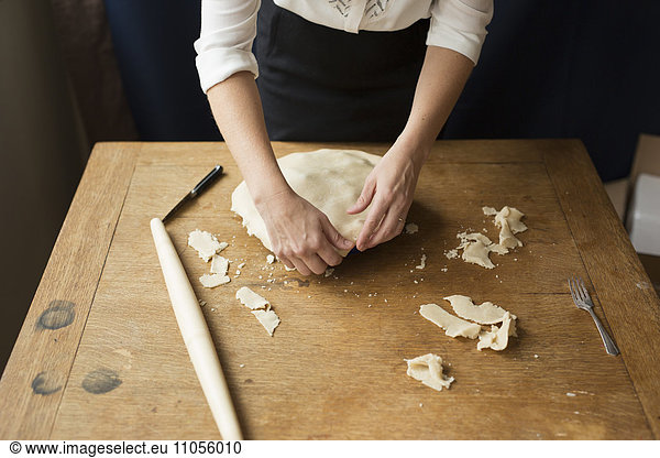 A woman crimping the pastry edge of a home made pie.