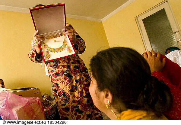 A woman displays gold jewelry at a wedding party.