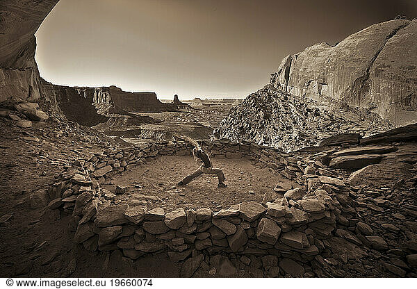 A woman doing Yoga in an Indian ruin in Canyonlands National Park  Utah.