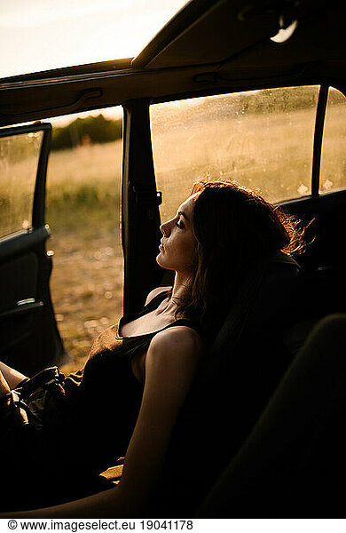 A woman enjoying the Sun in her car.