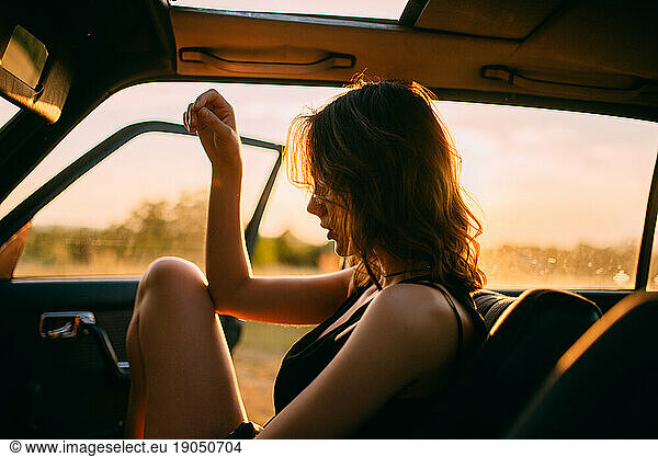 A woman enjoying the sun in her car.