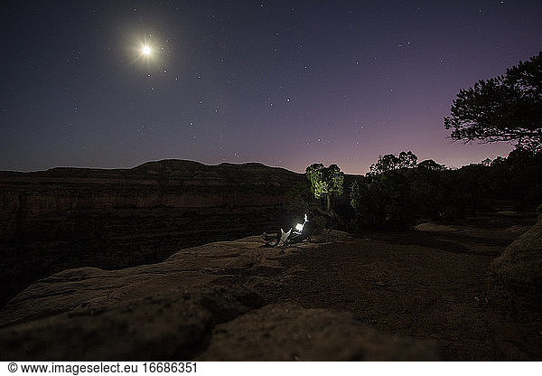 A woman enjoys a full moon near Colorado National Monument.