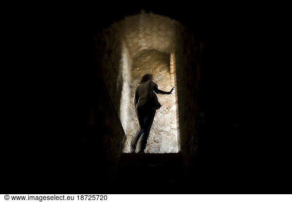 A woman enters an Andalusian fortress in Zahara de la Sierra village  Cadiz province  Andalusia  Spain.
