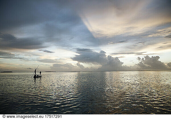 A woman fly fishing from a boat in the florida keys at sunset