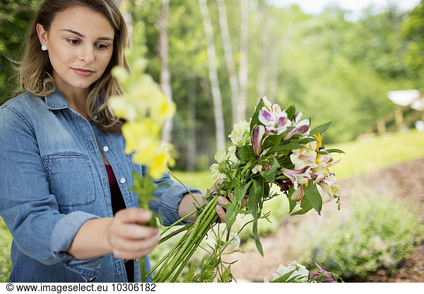 A woman holding a bunch of summer garden flowers.