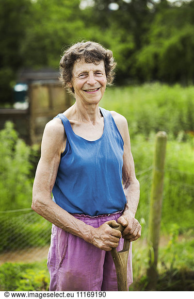 A woman holding a shovel on a farm.