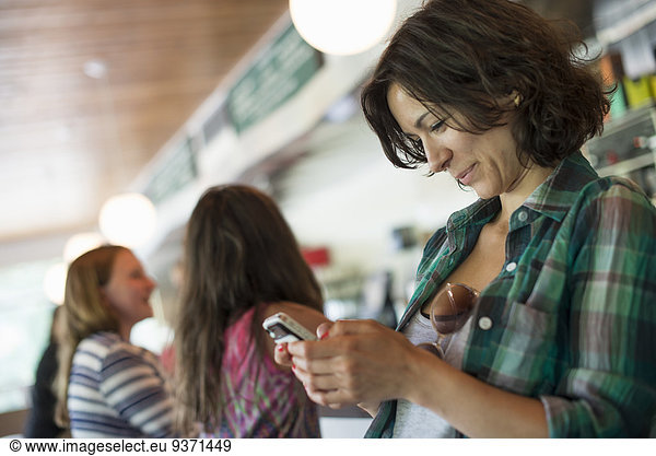 A woman in a diner  looking at her cell phone.