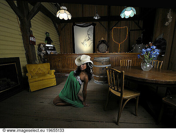 A woman in a green dress and cowboy hat in a wine bar  Clay  NY.