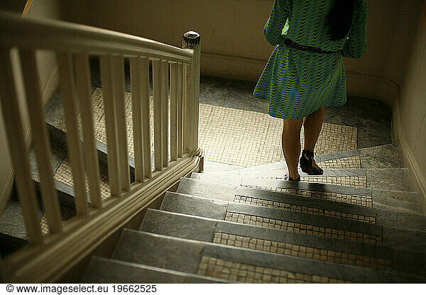 A woman in a green dress descends a flight of stairs in Taipei  Taiwan.
