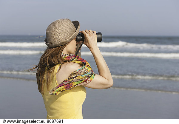 A woman in a sunhat and scarf on the beach on the New Jersey Shore  at Ocean City.