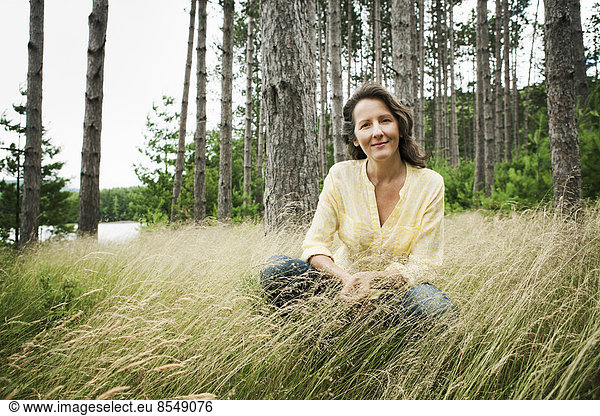 A woman in open countryside, by a mountain lake.