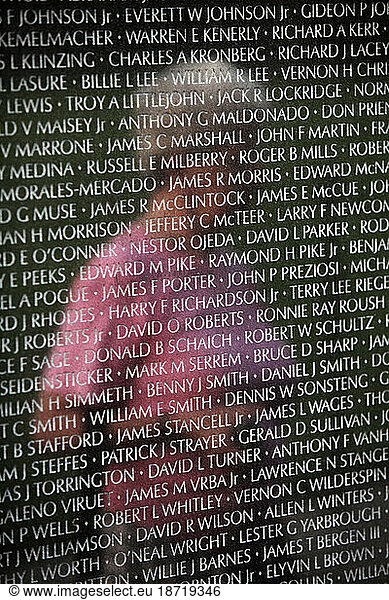 A woman is reflected in the Vietnam Veterans Memorial Wall in Washington  DC.