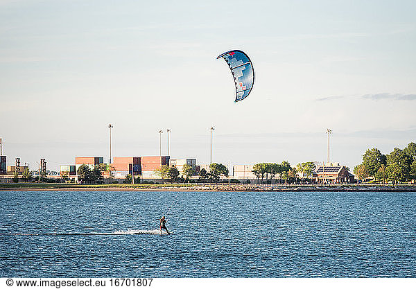 A woman kiteboarding in Pleasure Bay  Boston on a summer afternoon