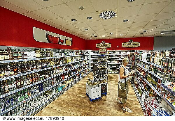 A woman looks at goods in the alcoholic beverages department  nah&frisch market  24497 Wanderup  Lower Saxony  Germany  Europe