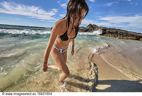 A woman plays in the waves on Makalawena Beach  Big Island Hawaii